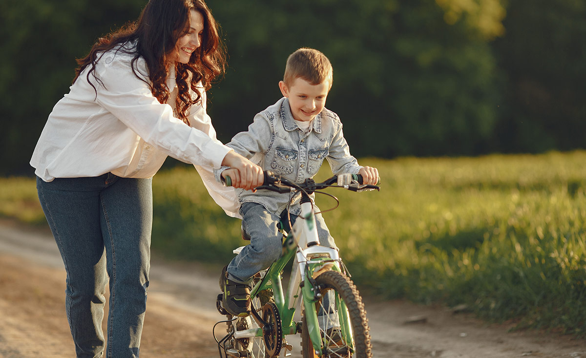 Mutter lernt Jungen radfahren